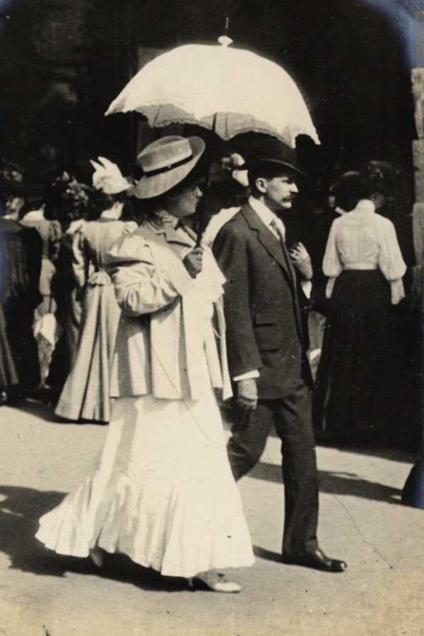 It looks like a warm day. The woman below is using her parasol. The fashion was for white complexions until the 1920s